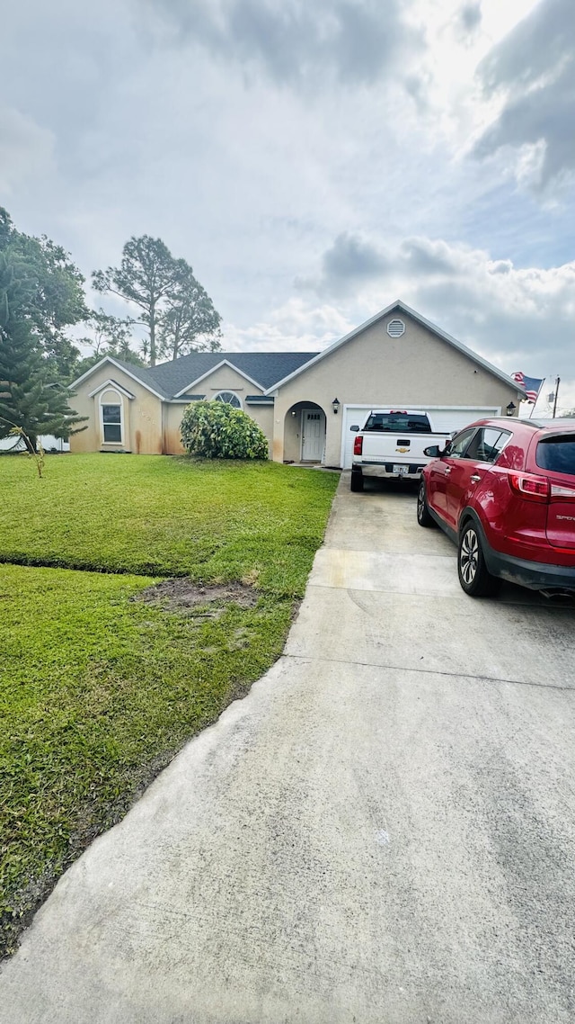 single story home with a front yard, a garage, and driveway