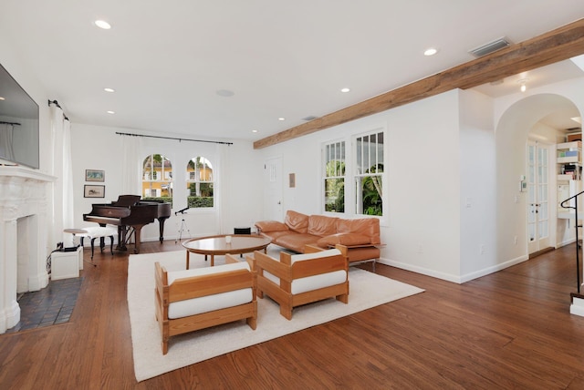 living room featuring visible vents, arched walkways, wood finished floors, and a fireplace