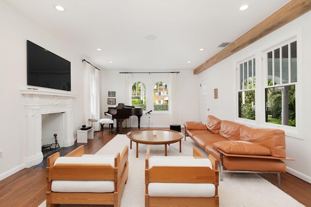 living room featuring visible vents, baseboards, recessed lighting, a fireplace, and wood finished floors