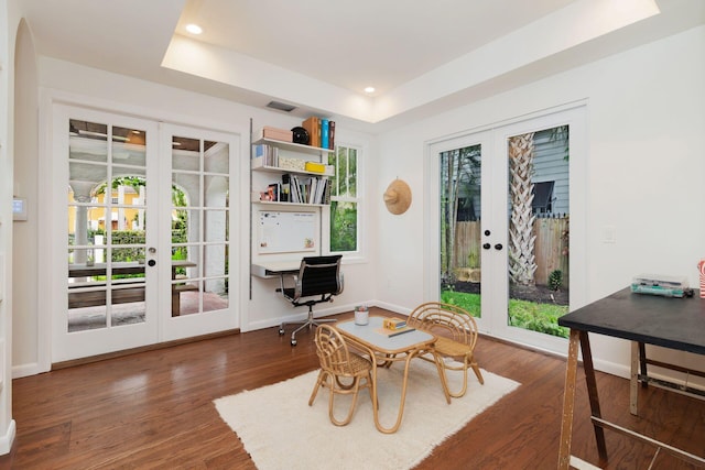 dining room with a tray ceiling, wood finished floors, french doors, and recessed lighting