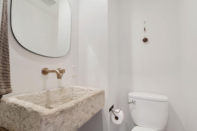 bathroom with a sink, visible vents, and toilet