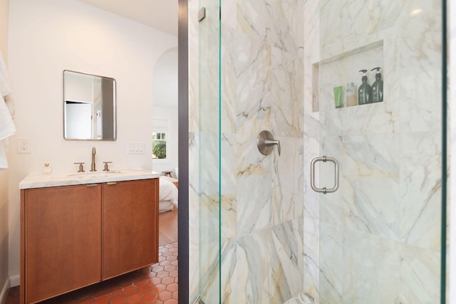 bathroom with vanity, ensuite bathroom, and a marble finish shower