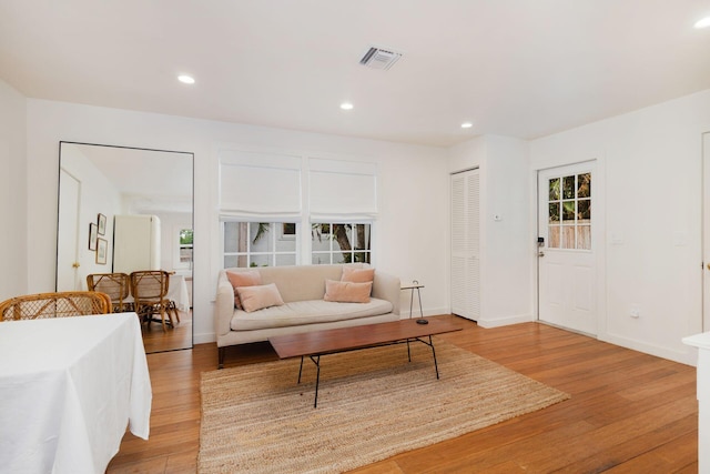 living room featuring recessed lighting, visible vents, light wood finished floors, and baseboards