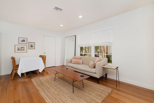 living room featuring visible vents, wood-type flooring, and baseboards