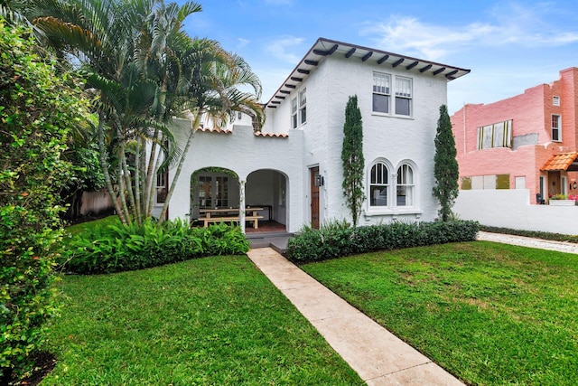 view of front of property with stucco siding and a front lawn