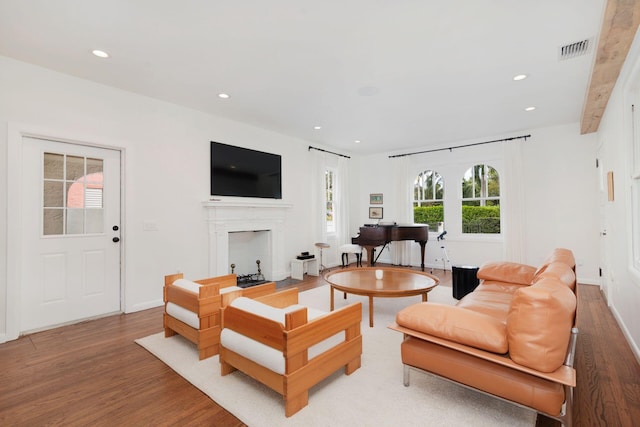 living room with visible vents, baseboards, light wood-style flooring, a fireplace, and recessed lighting