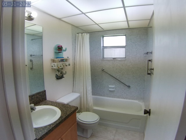 bathroom with tile patterned floors, toilet, shower / bath combo with shower curtain, and vanity