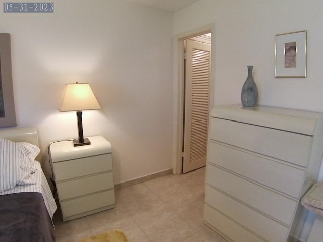 bedroom with light tile patterned floors and baseboards