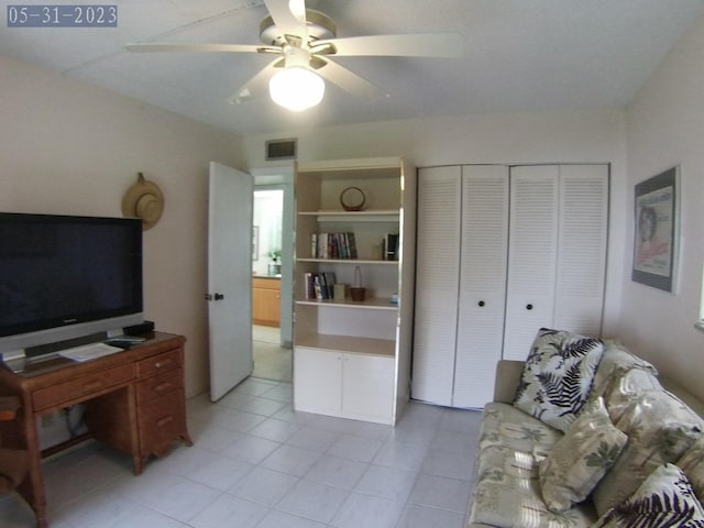 living area featuring light tile patterned floors, visible vents, and a ceiling fan