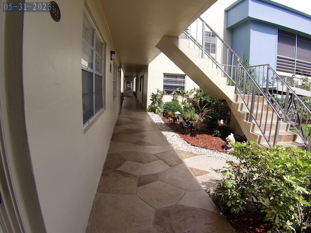 view of side of property featuring stucco siding and stairs