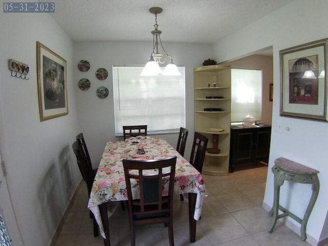 dining room featuring light tile patterned floors and a textured ceiling