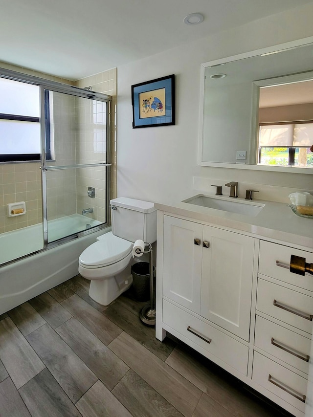 13321 Polo Club Rd Unit C103, Wellington, FL 33414 - bathroom featuring wood finish floors, combined bath / shower with glass door, toilet, and vanity