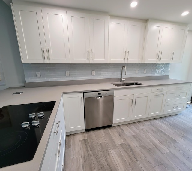 13321 Polo Club Rd Unit C103, Wellington, FL 33414 - kitchen with light wood-type flooring, stainless steel dishwasher, white cabinets, black electric cooktop, and a sink