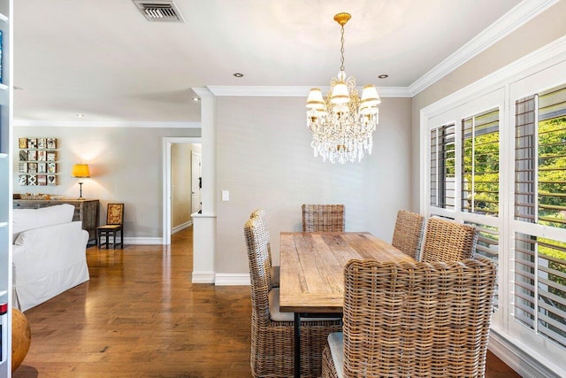 dining area featuring visible vents, baseboards, ornamental molding, an inviting chandelier, and wood finished floors