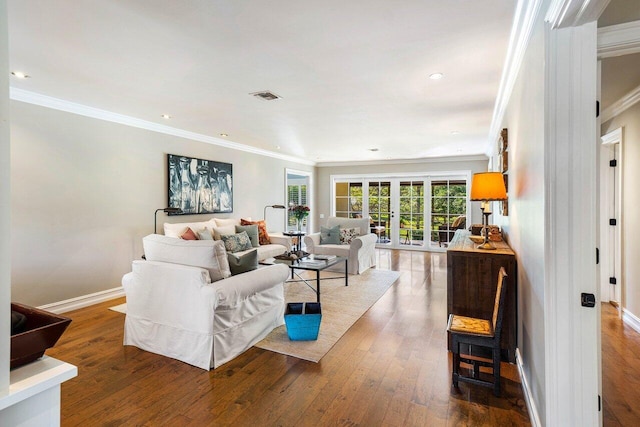 living room featuring visible vents, crown molding, baseboards, and hardwood / wood-style flooring