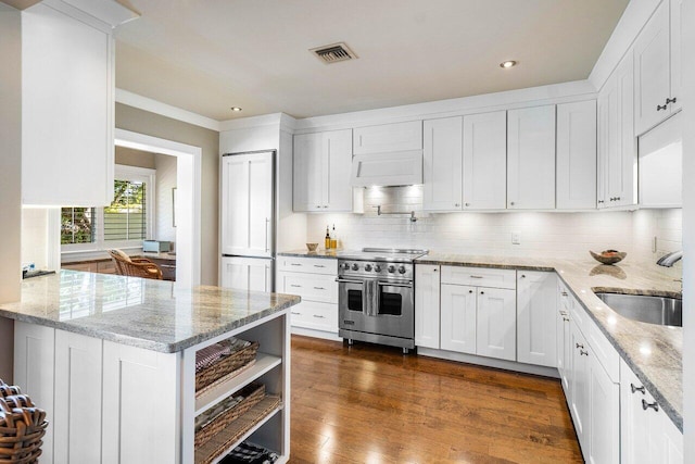 kitchen with visible vents, white cabinets, stainless steel stove, and a sink