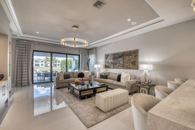 living room featuring a tray ceiling, a textured ceiling, visible vents, and light tile patterned flooring