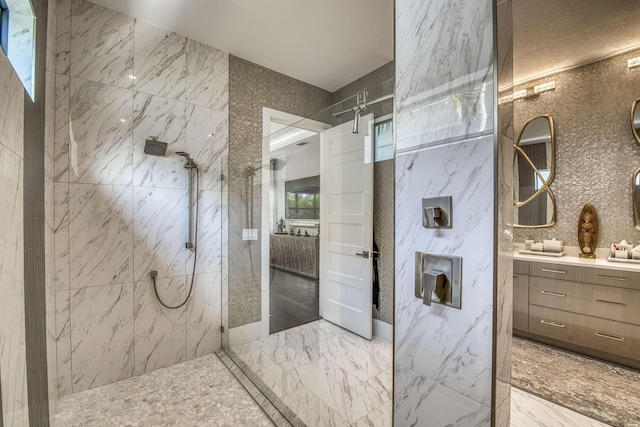 bathroom with vanity, marble finish floor, and a marble finish shower