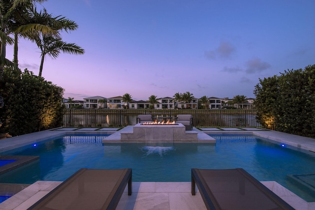 pool at dusk featuring a fenced in pool, a fire pit, and a fenced backyard