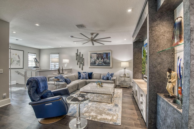 living room with visible vents, dark wood-style flooring, and a textured ceiling