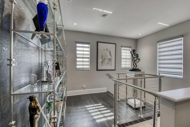 home office featuring a textured ceiling, baseboards, and hardwood / wood-style floors