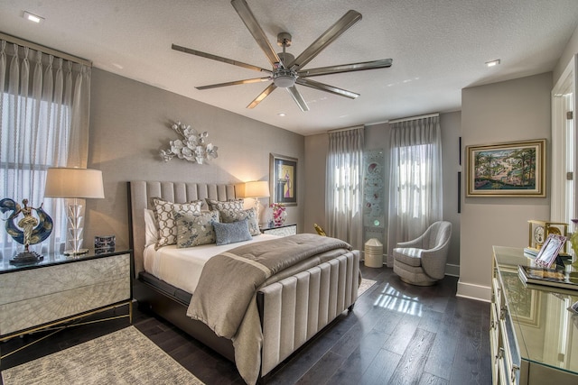 bedroom with dark wood finished floors, baseboards, a textured ceiling, and ceiling fan