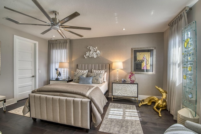 bedroom featuring visible vents, baseboards, wood finished floors, a textured ceiling, and a ceiling fan