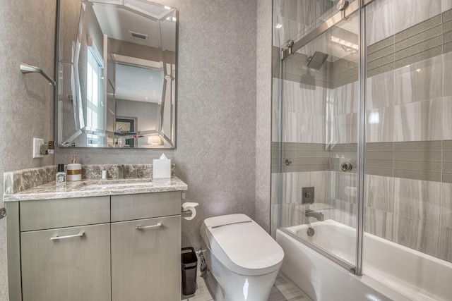 bathroom featuring visible vents, toilet, a textured wall, combined bath / shower with glass door, and vanity