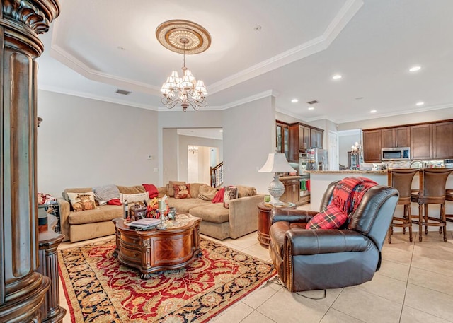 living room with visible vents, a tray ceiling, crown molding, light tile patterned floors, and a chandelier