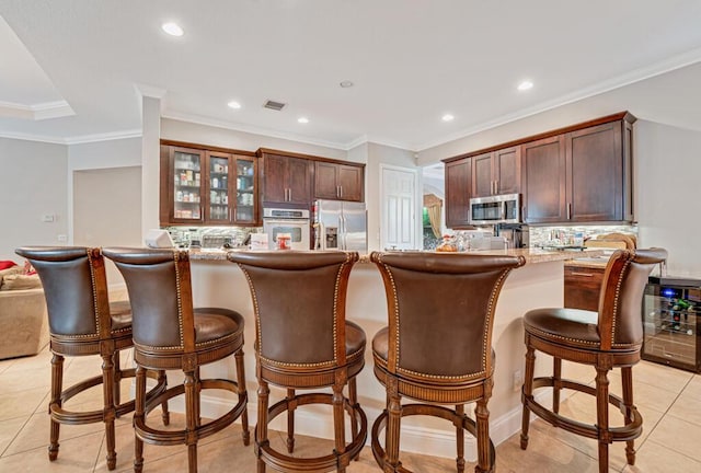 kitchen featuring stainless steel appliances, wine cooler, a peninsula, and decorative backsplash