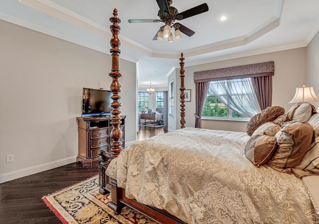 bedroom featuring crown molding, baseboards, ceiling fan with notable chandelier, wood finished floors, and a raised ceiling