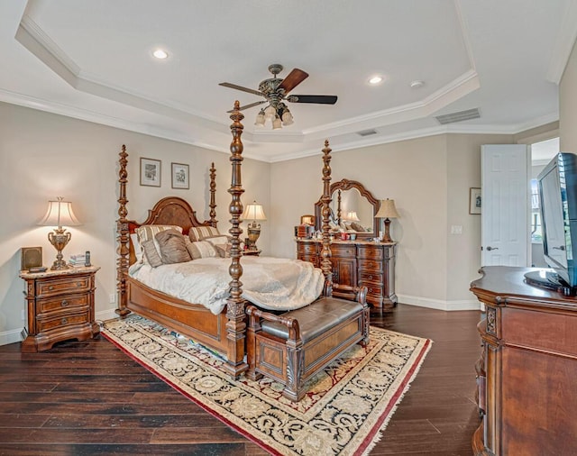 bedroom with visible vents, crown molding, a raised ceiling, and dark wood-style flooring