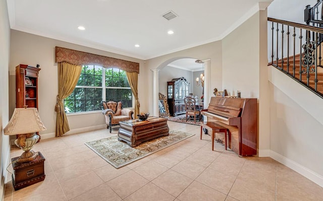 living area featuring ornamental molding, stairway, arched walkways, baseboards, and ornate columns