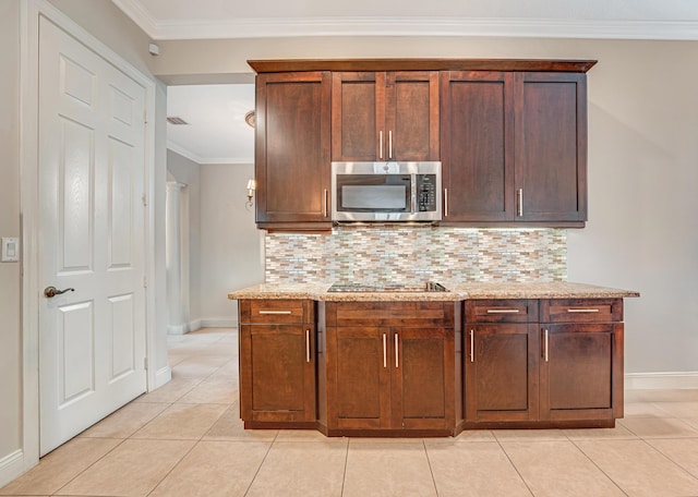 kitchen featuring light tile patterned floors, ornamental molding, stainless steel microwave, black electric stovetop, and tasteful backsplash