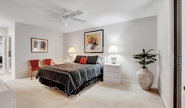 carpeted bedroom with a textured ceiling, ceiling fan, and baseboards