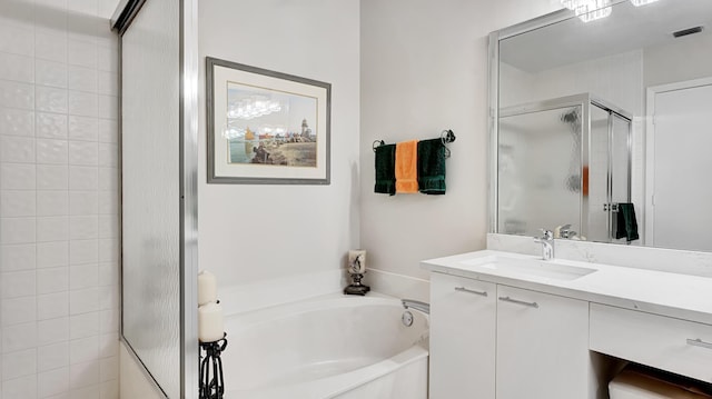 bathroom featuring a garden tub, a shower stall, visible vents, and vanity