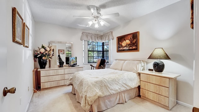bedroom featuring a textured ceiling, ceiling fan, light colored carpet, and baseboards