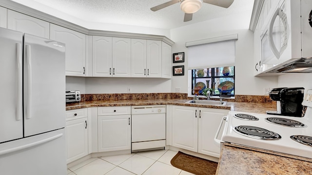 kitchen featuring white appliances, light tile patterned floors, ceiling fan, a sink, and white cabinetry