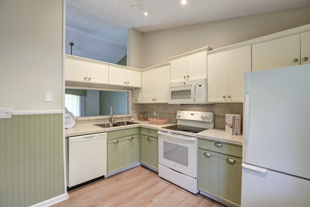 kitchen featuring a sink, white appliances, light wood-style flooring, and light countertops