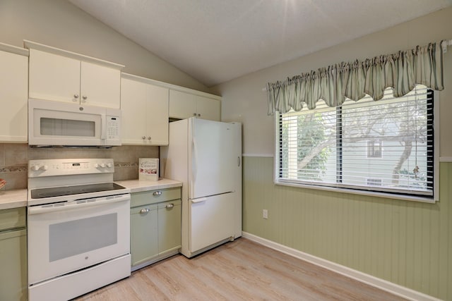 kitchen with light wood-type flooring, light countertops, lofted ceiling, white appliances, and white cabinetry