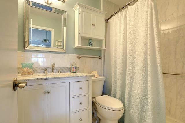 full bath featuring curtained shower, toilet, tile walls, and vanity