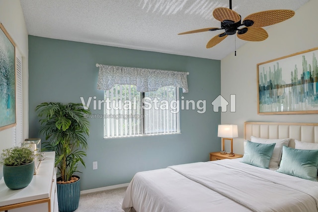 carpeted bedroom with a textured ceiling, baseboards, and a ceiling fan