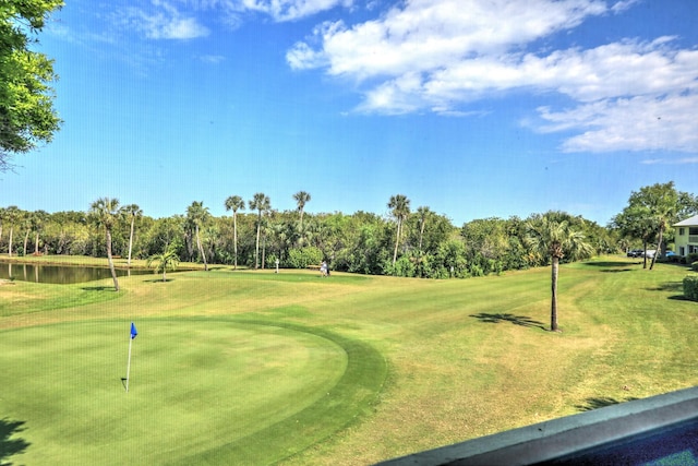 view of home's community featuring a lawn, golf course view, and a water view