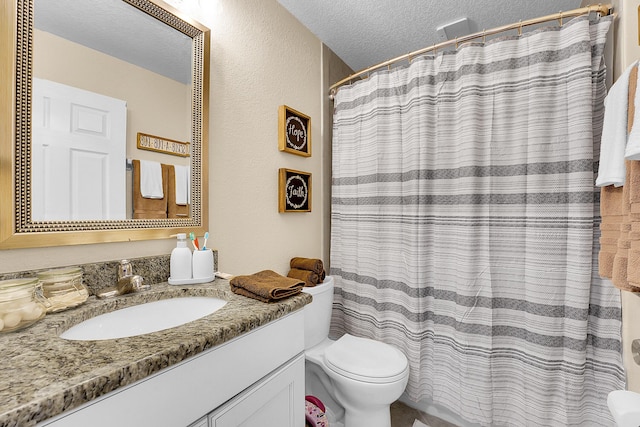 full bath with curtained shower, a textured ceiling, vanity, and toilet