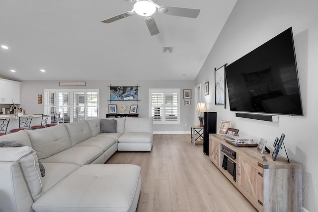 living room featuring visible vents, baseboards, lofted ceiling, recessed lighting, and light wood-style flooring