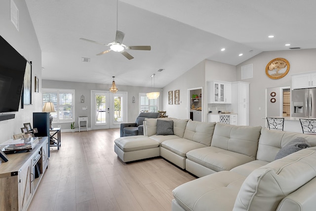 living area with a ceiling fan, light wood-style floors, visible vents, and french doors