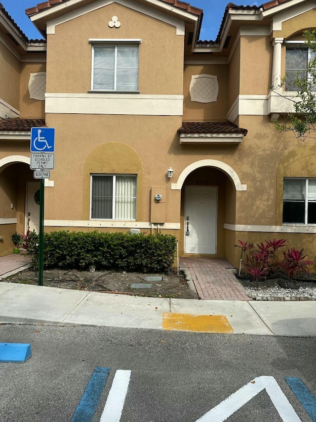 townhome / multi-family property featuring stucco siding and a tiled roof