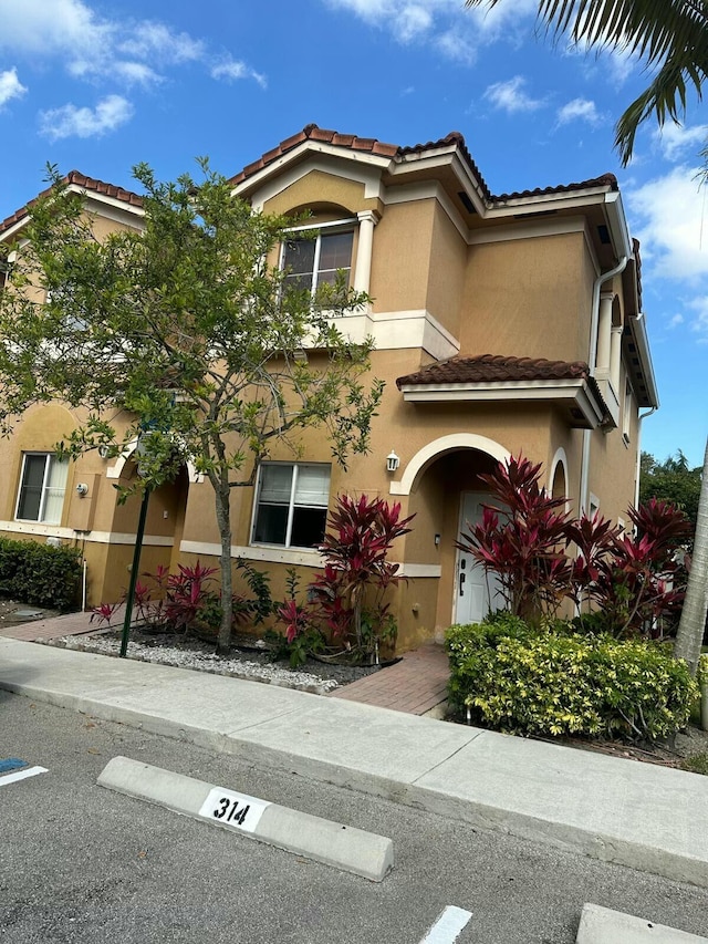 view of front of house with a tile roof and stucco siding