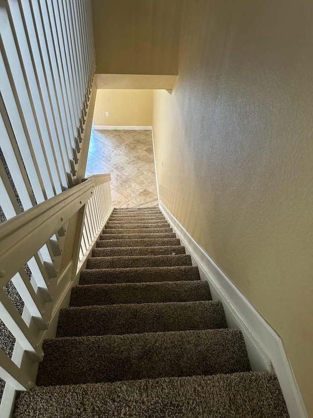 staircase featuring baseboards