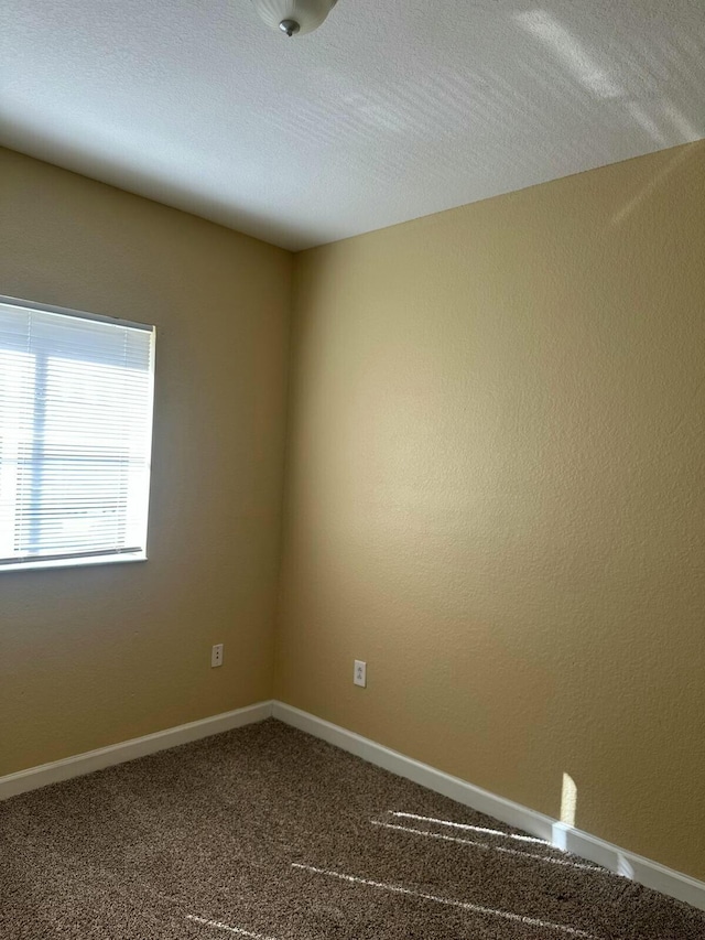 carpeted spare room with baseboards